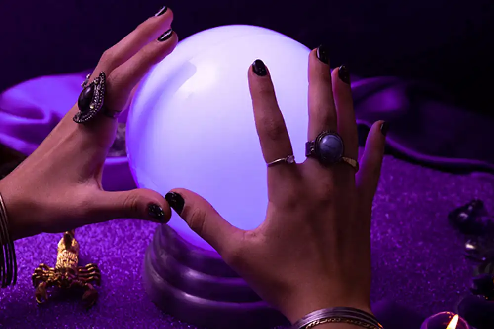 Mãos sobre uma esfera de cristal iluminada